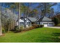 Mature trees accent this charming single-story home with attached two-car garage and well-maintained front lawn at 1190 Saint Ives Ct, Suwanee, GA 30024