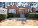 Charming brick home showcasing a manicured lawn, dark shutters, and lovely landscaping at 1251 Cumberland Ne Rd, Atlanta, GA 30306