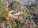 Stunning aerial view of the house surrounded by lush greenery and a serene creek at 241 Nacoochee Dr, Woodstock, GA 30188