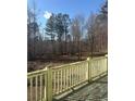 Backyard scenery with a wooden deck overlooking a wooded area with lots of tall trees at 241 Nacoochee Dr, Woodstock, GA 30188