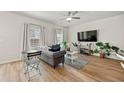 Bright living room featuring hardwood floors, a ceiling fan, and natural light streaming through the windows at 6372 Rosetta Sw Dr, Atlanta, GA 30331