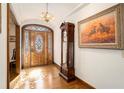 Elegant foyer featuring wood flooring, an antique clock and a beautiful wooden door at 6575 Roundhill Ct, Cumming, GA 30040