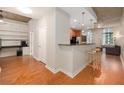 Open-concept living space with hardwood floors, kitchen bar, built-in shelving, and exposed concrete accents at 855 Peachtree Ne St # 1911, Atlanta, GA 30308