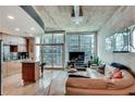 Living room and kitchen area showcasing concrete ceilings, hardwood floors, and glass balcony doors at 923 Peachtree Ne St # 1527, Atlanta, GA 30309