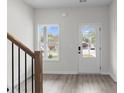 Bright foyer featuring wood-look flooring, a staircase, and a front door with glass panels at 2949 Jefferson St, Austell, GA 30106