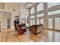Elegant living room with hardwood floors, fireplace, and large windows providing ample natural light at 525 Water Shadow Ln, Alpharetta, GA 30022