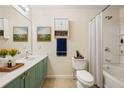 Cozy bathroom with shower and tub, storage cabinet, and a framed landscape art piece at 1536 Liberty Nw Pkwy, Atlanta, GA 30318