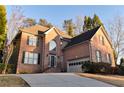 Elegant two-story brick home featuring a well-manicured lawn and driveway at 4129 Lansfaire Ter, Suwanee, GA 30024