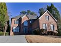 Beautiful brick two-story home with a well-maintained lawn on a sunny day at 4129 Lansfaire Ter, Suwanee, GA 30024