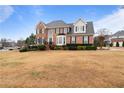 Inviting brick home with lush landscaping and a spacious front yard on a sunny day at 5292 Candleberry Sw Dr, Lilburn, GA 30047