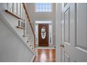 Bright foyer featuring hardwood floors, an elegant staircase, and a decorative front door at 5292 Candleberry Sw Dr, Lilburn, GA 30047