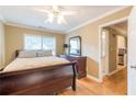 A cozy bedroom featuring wood floors, a ceiling fan, and a view into the en-suite bathroom and hallway at 885 Briarcliff Ne Rd # D3, Atlanta, GA 30306