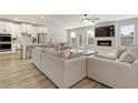 Open living room with white sofa, fireplace, and adjacent kitchen and dining area at 2286 Cadenza Cir, Dacula, GA 30019