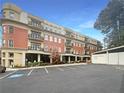 Condo building featuring red brick, balconies, and dedicated parking spaces surrounded by greenery at 560 Dutch Valley Ne Rd # 2301, Atlanta, GA 30324