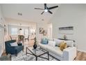 Bright living room with vaulted ceiling, ceiling fan, modern furniture, and decor leading into the adjacent kitchen and dining area at 1493 Buckeye Ter, Auburn, GA 30011