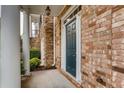 Close-up of the front door of a brick townhome with white trim and a dark blue door at 10828 Yorkwood Street, Johns Creek, GA 30097