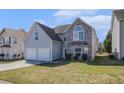 Charming home with a two-car garage, stone accents, and well-maintained front lawn at 11643 Sarah Loop, Hampton, GA 30228