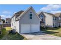 View of the home's side and back featuring a two-car garage and well-kept lawn at 11643 Sarah Loop, Hampton, GA 30228