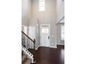 Bright foyer with hardwood floors, tall ceilings, staircase with iron railings, and a front door with glass panels at 702 Ridgeway Ct, Canton, GA 30114