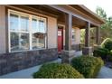 Inviting front porch with stone pillars, hanging flower baskets, and a vibrant red front door at 702 Ridgeway Ct, Canton, GA 30114