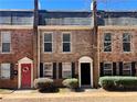 Brick townhouse featuring a red door with flower wreath and a well maintained exterior and landscape at 235 Winding River Dr # B, Sandy Springs, GA 30350