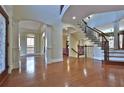 Grand foyer with hardwood floors, soaring ceilings, decorative columns, and a wrought iron staircase, offering a luxurious entrance at 2650 Riverfront Dr, Snellville, GA 30039