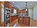 Well-appointed kitchen featuring custom cabinetry, granite countertops, stainless steel appliances, and hardwood floors at 2650 Riverfront Dr, Snellville, GA 30039