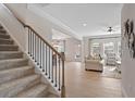 Open living room with light wood floors, a staircase, and a view into the dining room at 523 Lanier Way, Temple, GA 30179