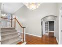 Bright foyer with staircase, hardwood floors, and an arched entrance to another room at 925 Sentry Ridge Xing, Suwanee, GA 30024
