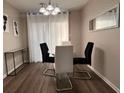 Dining area featuring modern light fixture, a glass table, and neutral tones at 5609 Windwood Rd, Atlanta, GA 30349