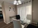 Dining area featuring modern light fixture, a glass table, and neutral tones at 5609 Windwood Rd, Atlanta, GA 30349