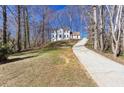 A two-story home sits atop a hill, accessed by a long, private driveway at 5050 Brownwood Dr, Powder Springs, GA 30127