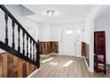 Inviting foyer with wood-look flooring, decorative wood trim, and a staircase with black railings at 5050 Brownwood Dr, Powder Springs, GA 30127
