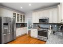 Modern kitchen featuring granite countertops, stainless steel appliances and custom white cabinets with glass inserts at 2164 Caneridge Sw Dr, Marietta, GA 30064