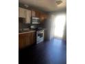 Kitchen area with wood cabinets, an oven and stove, and wood floors at 405 Fairburn Sw Rd, Atlanta, GA 30331