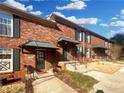 View of charming brick townhomes with black shutters and covered entryways on a sunny day at 5676 Kingsport Dr # 4, Atlanta, GA 30342