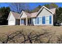 Attractive single story house with blue shutters, attached garage, and mature landscaping at 67 Mossy Oak Ln, Dallas, GA 30157