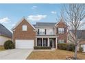 Charming two-story home with a brick facade, a well-manicured lawn, and an attached two-car garage at 5932 Vinings Vintage Way, Mableton, GA 30126