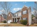 Charming two-story home with a brick facade, a well-manicured lawn, and an attached two-car garage at 5932 Vinings Vintage Way, Mableton, GA 30126