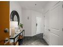 Hallway with black marble floor and white walls, designer table and mirror with doors leading to rooms at 943 Peachtree Ne St # 1108, Atlanta, GA 30309