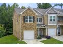 Charming townhome showcasing brick facade, front lawn and attached single-car garage at 10166 Benton Woods Dr, Covington, GA 30014