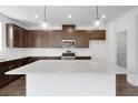 Spacious kitchen with granite counters, stainless appliances, dark wood cabinets, and a large island at 1420 Windance Lake Dr, Loganville, GA 30052
