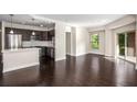 Sun-filled living room with dark wood floors, stainless steel kitchen appliances and access to the patio at 200 River Vista Dr # 205, Atlanta, GA 30339