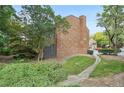 Back of the brick townhome featuring mature trees and greenery providing a sense of nature at 7 Newport Nw Pl, Atlanta, GA 30318