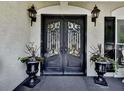 Elegant, wrought-iron front door with decorative planters on either side creates a welcoming entry at 1012 Jubilee Way, Powder Springs, GA 30127