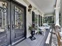 Inviting front porch with elegant double door, rocking chairs, and stylish exterior lighting at 1012 Jubilee Way, Powder Springs, GA 30127