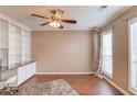 Home office with built-in shelves, hardwood floors, natural light, and a ceiling fan at 1042 Wildwood Wake Bnd, Dacula, GA 30019