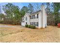 View of home showing the attached two-car garage, well-maintained lawn, and mature trees surrounding the property at 3999 Craggy Perch, Douglasville, GA 30135