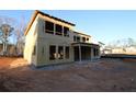 Image shows the side and rear of a house in the framing stage with a covered patio area, under construction at 436 Maypop Lane, Woodstock, GA 30188