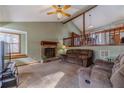 Inviting living room with a vaulted ceiling, exposed beams, stone fireplace, and large picture window at 715 Wallington Way, Lawrenceville, GA 30046